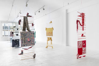Multimedia fiber sculptures by Jade Yumang suspended from the ceiling in a gallery space. 