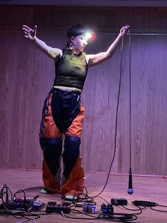 A person holding a microphone with a light around their head