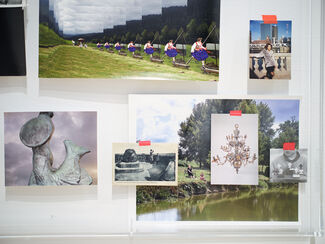 Various portraits and subjects displayed on a blank wall. 