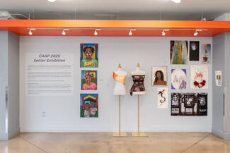 A wall at the CAAP 2025 Senior Exhibition, featuring multiple art works hanging on the wall and two mannequins wearing student work.