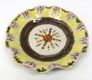A ceramic pie plate in yellow, brown, and pink tones.