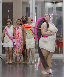 Six performers stand on stage.