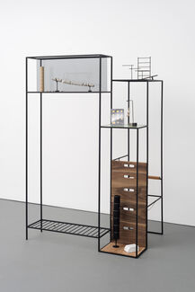 An installation of objects placed on a shelf-like structure.