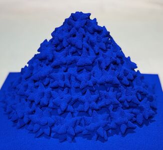 Bright blue cone-shaped pile of star-like shapes by Gunjan Chawla Kumar. 