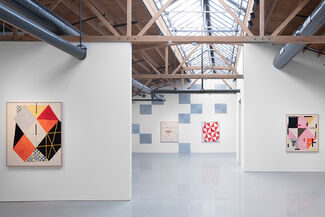 An installation view of an exhibition with colorful paintings on the wall.