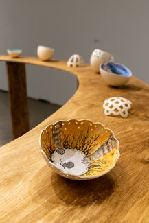 Detail of painted eggshells by Emily Miller displayed on a round table.