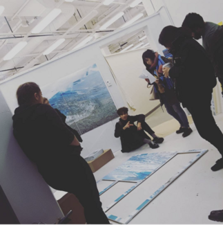 Students of varying ethnicities, ages, and genders view artwork.