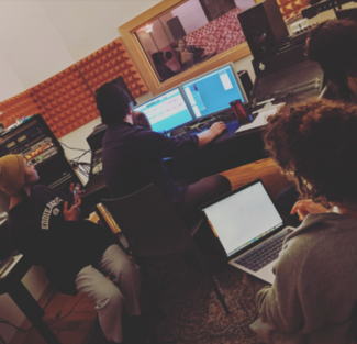 Four people in a recording studio.