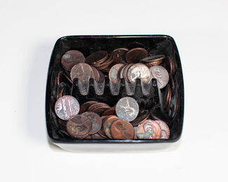 A black containter of various pennies. 