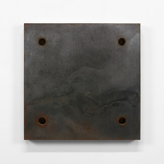 A dark gray square-shaped block with a marbled texture and four holes. 