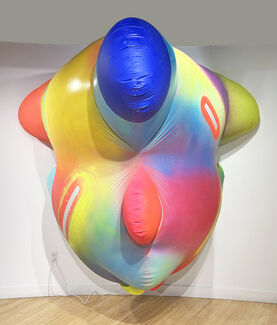 A brightly painted inflatable sculpture attached to a gallery wall.