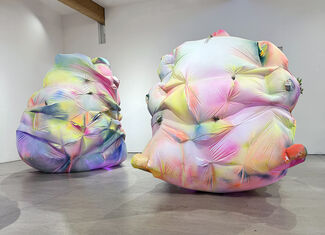 Colorful inflatable art installations inside a gallery setting.