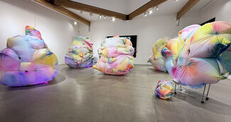 Colorful inflatable art installations inside a gallery setting.