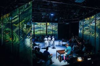 Performers and an audience in a black box theater. 