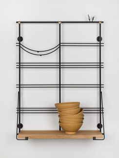 Nine stacked brown bowls on a hanging shelf. 