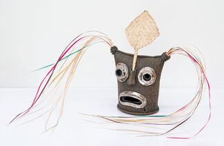 Brown and woven sculptural mask of a face.