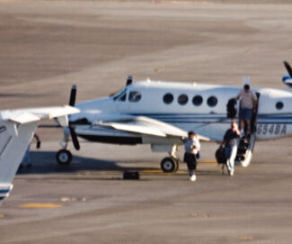 Blurry image of people deboarding an airplane.