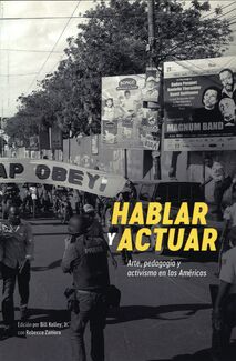 Black and white photo of a march with Talking to Action written in Spanish