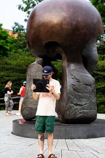 People in Nuclear Energy Plaza use AR to see the How do we trouble time exhibit