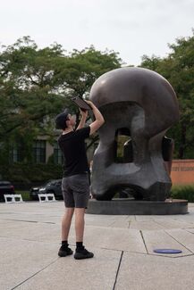 A man in Nuclear Energy Plaza use AR to see the How do we trouble time exhibit