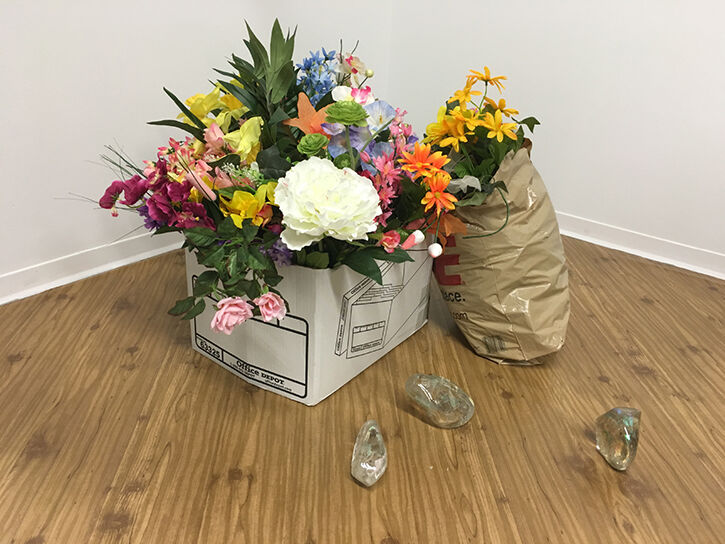 A floral piece next to large pieces of glass.