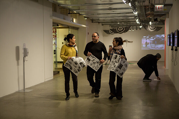 A group of people walking through an art gallery.