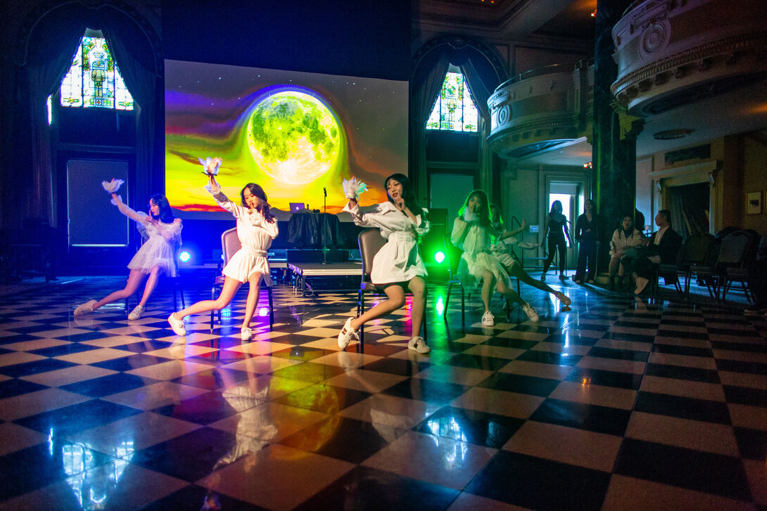 Students dance in front of a projection of the moon at the Chinese Cultural Festival event.