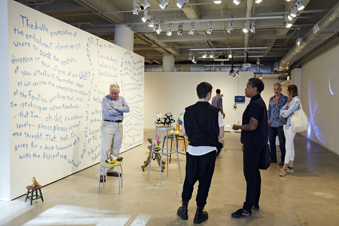 People standing and talking in art gallery