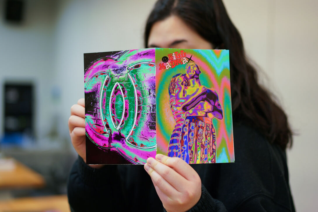 Student holding up a colorful zine