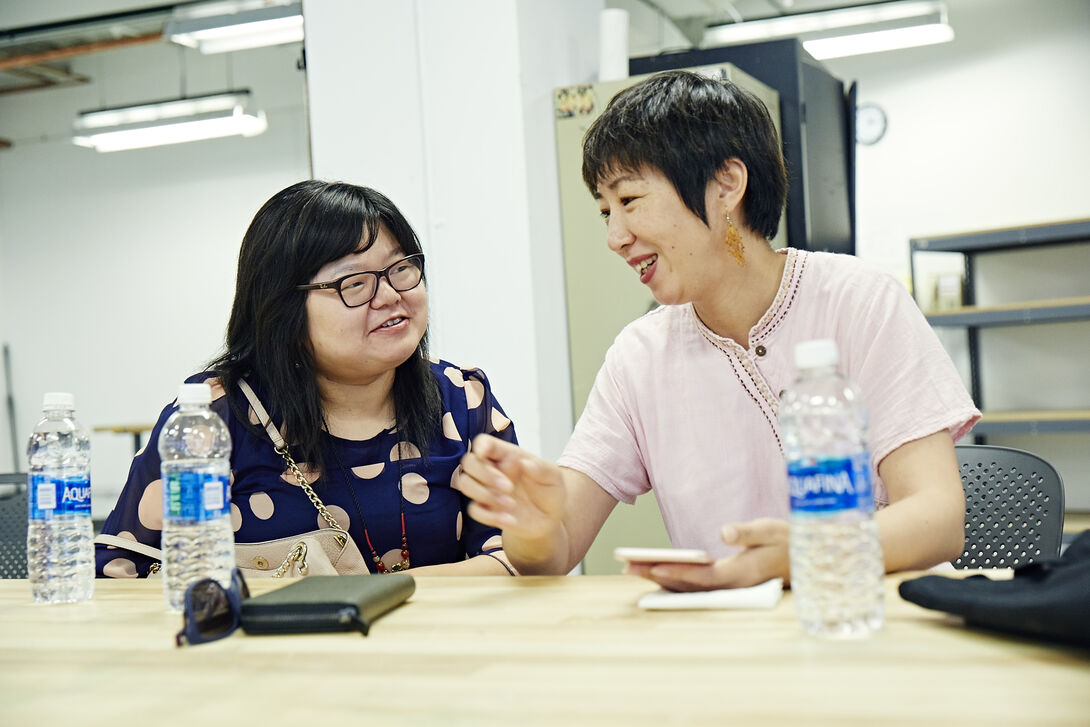 Two people conversing at a table. 