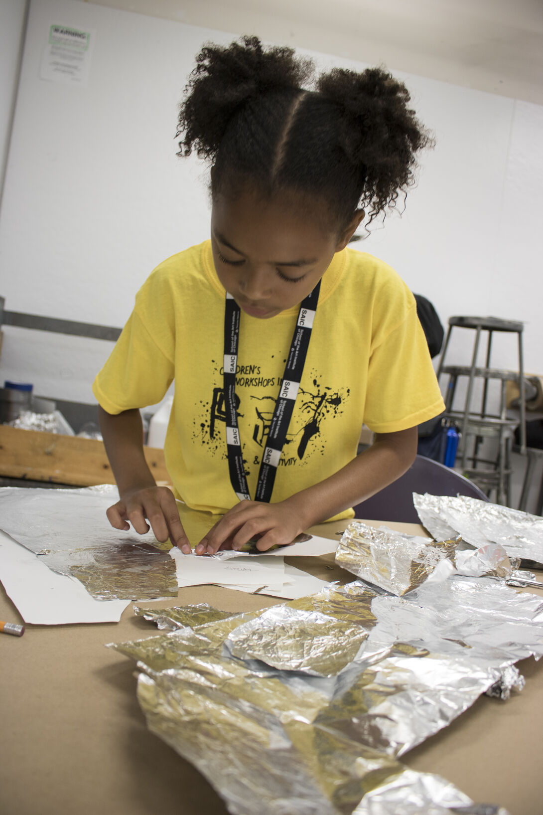 A young student working with foil to create art. 