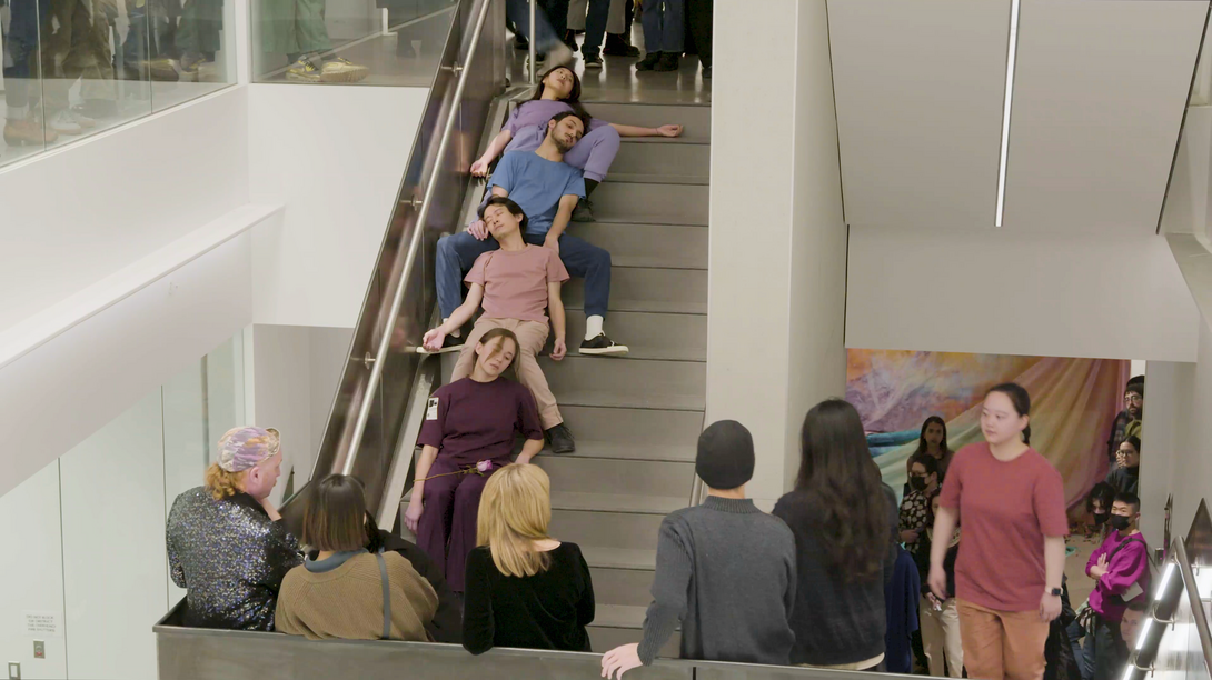 A group of students performing on the steps of the SAIC galleries as a crowd observes
