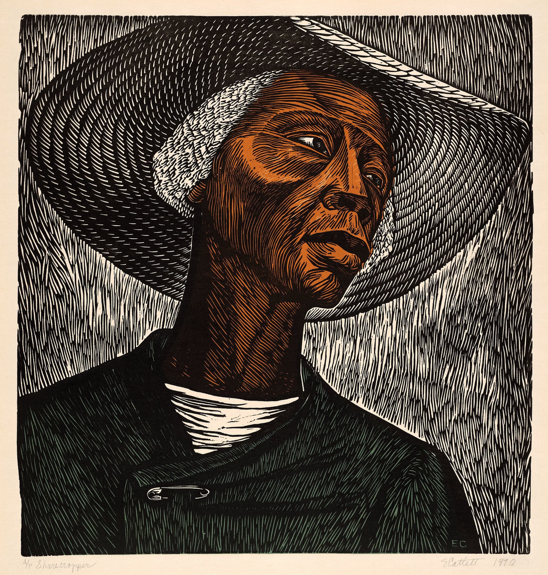 Linocut print of an older Black woman wearing a wide-brimmed hat and coat, gazing upward. Bold carved lines emphasize texture and expression. Created by Elizabeth Catlett, titled Sharecropper (1970).