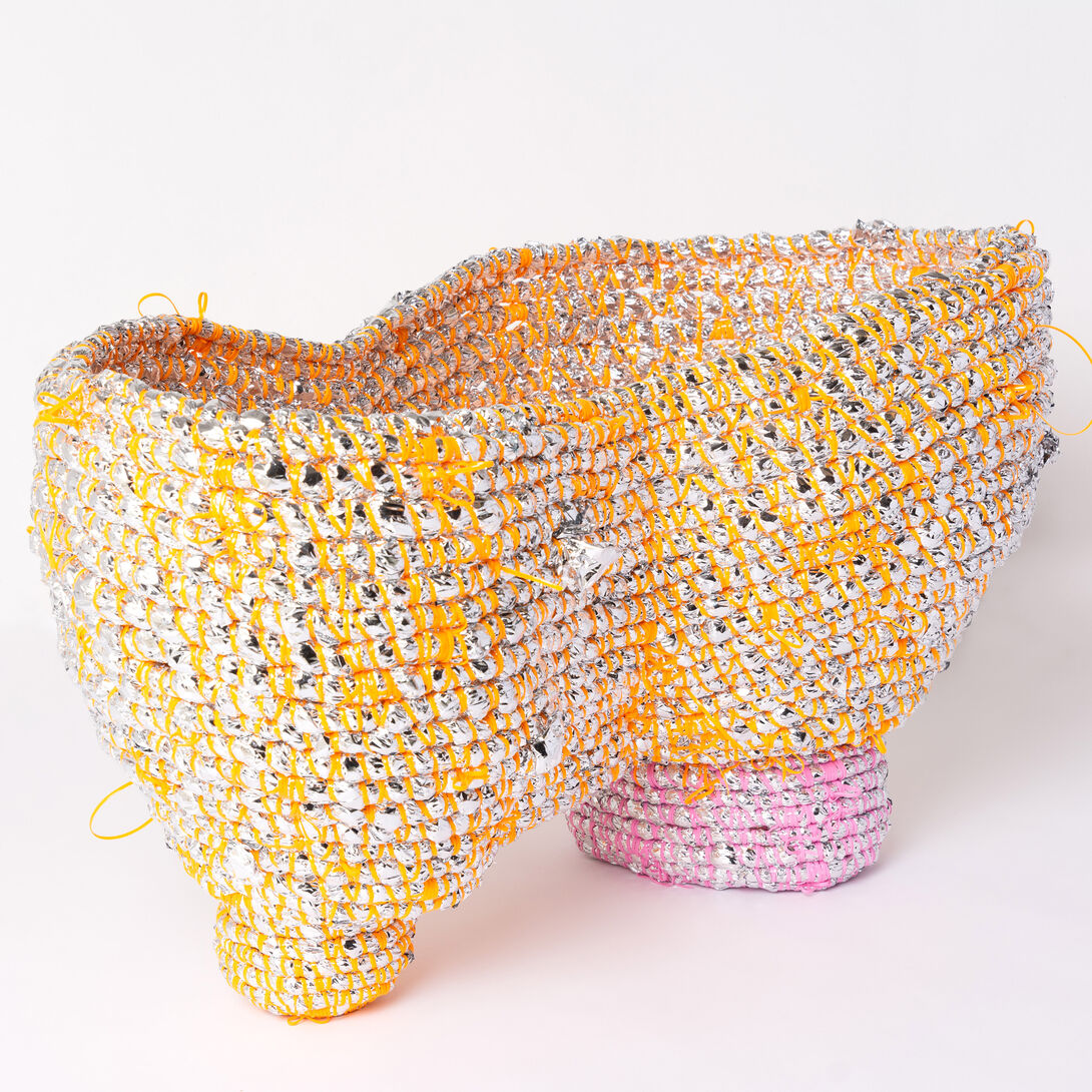 A silver, orange and pink coiled basket with two separate bases, but the main part of the vessel is one. 