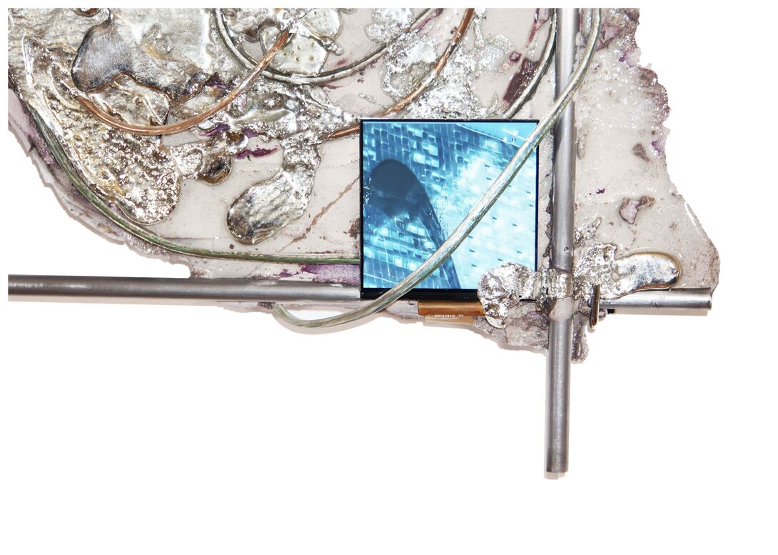 Detail view of Dwelling in the Mirage, a wall-mounted installation featuring a small embedded screen playing looping footage of reflective glass architecture, surrounded by steel rods, resin, concrete, and translucent tubing.