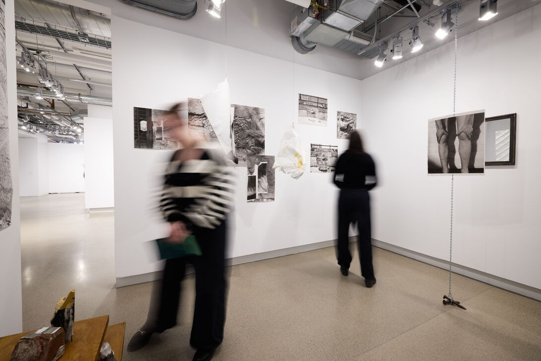 Two blurry people view art in a gallery. 