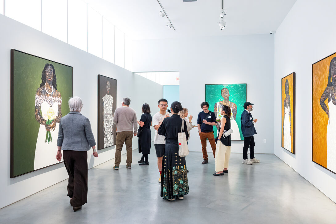 Adults of varying ages, ethnicities, and genders at an event in a gallery.