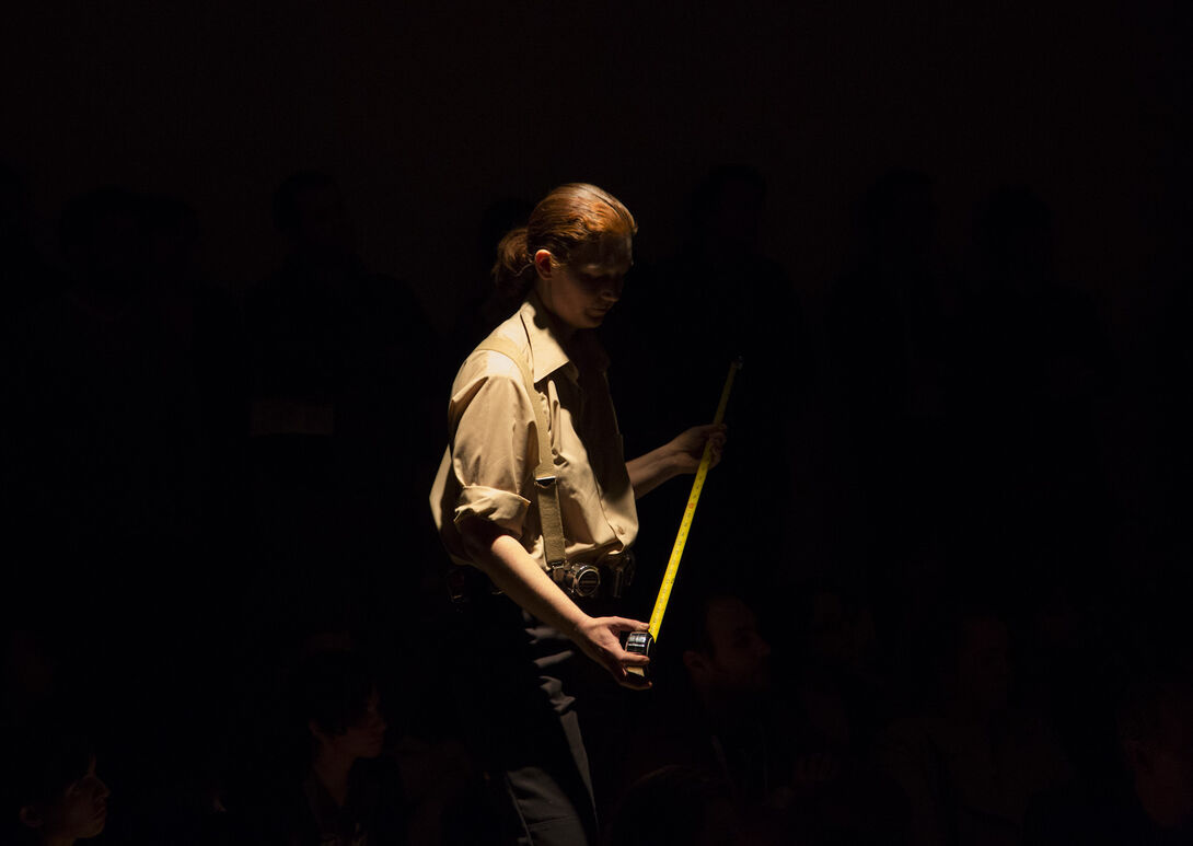A student performing a piece of performance art on a dark stage