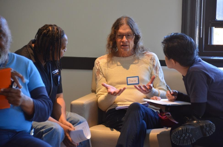 Three seated individuals engage in a conversation at the Center on Halsted