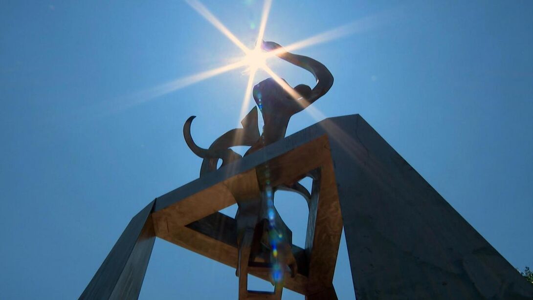 Image of Richard Hunt's sculpture Light of Truth against a blue sky