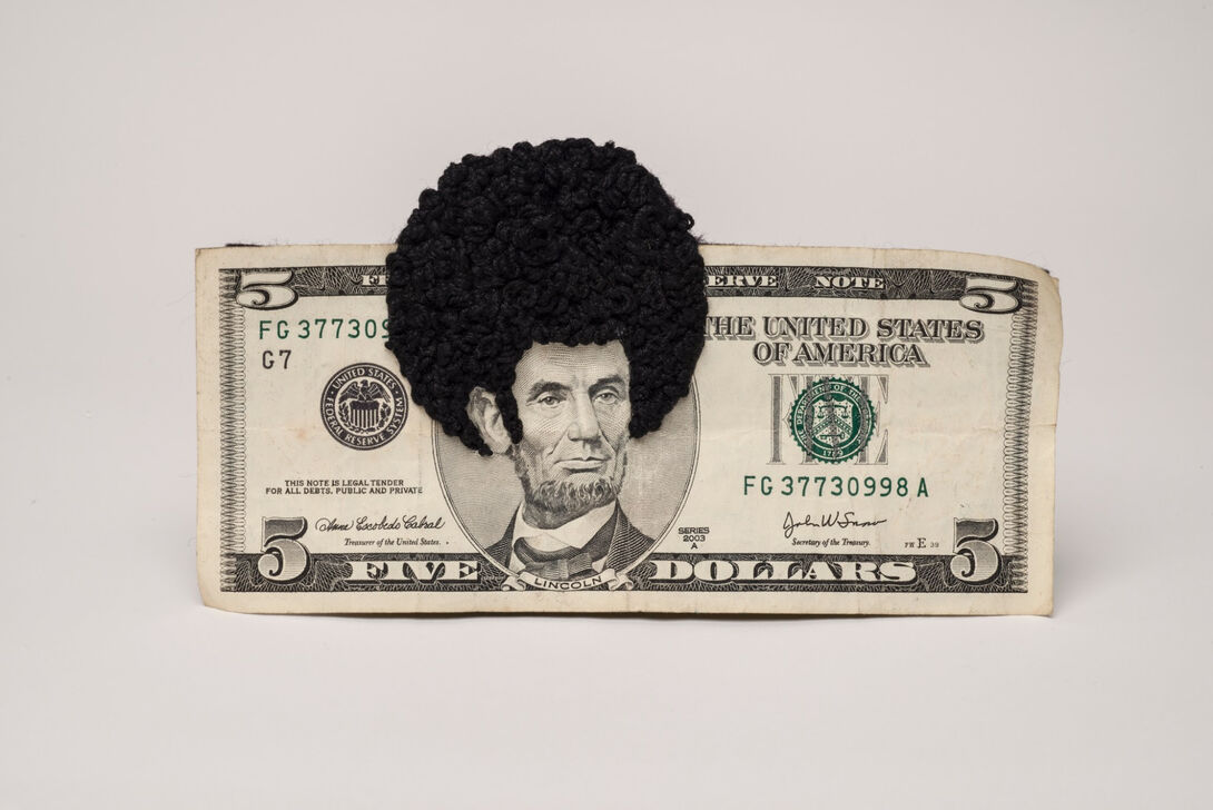 A five-dollar bill with an afro sewn on Abraham Lincoln